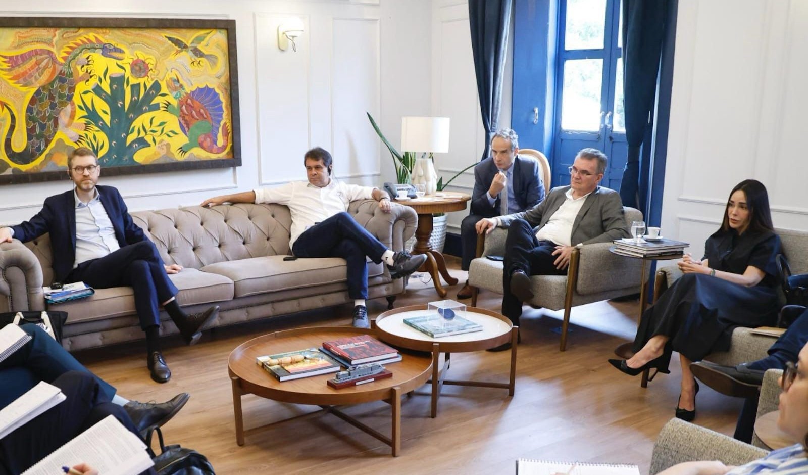 grupo de pessoas reunidas numa sala e sentadas em sofás